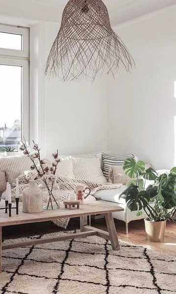 Open-weave pendant above a white sofa and a cream rug with black lines