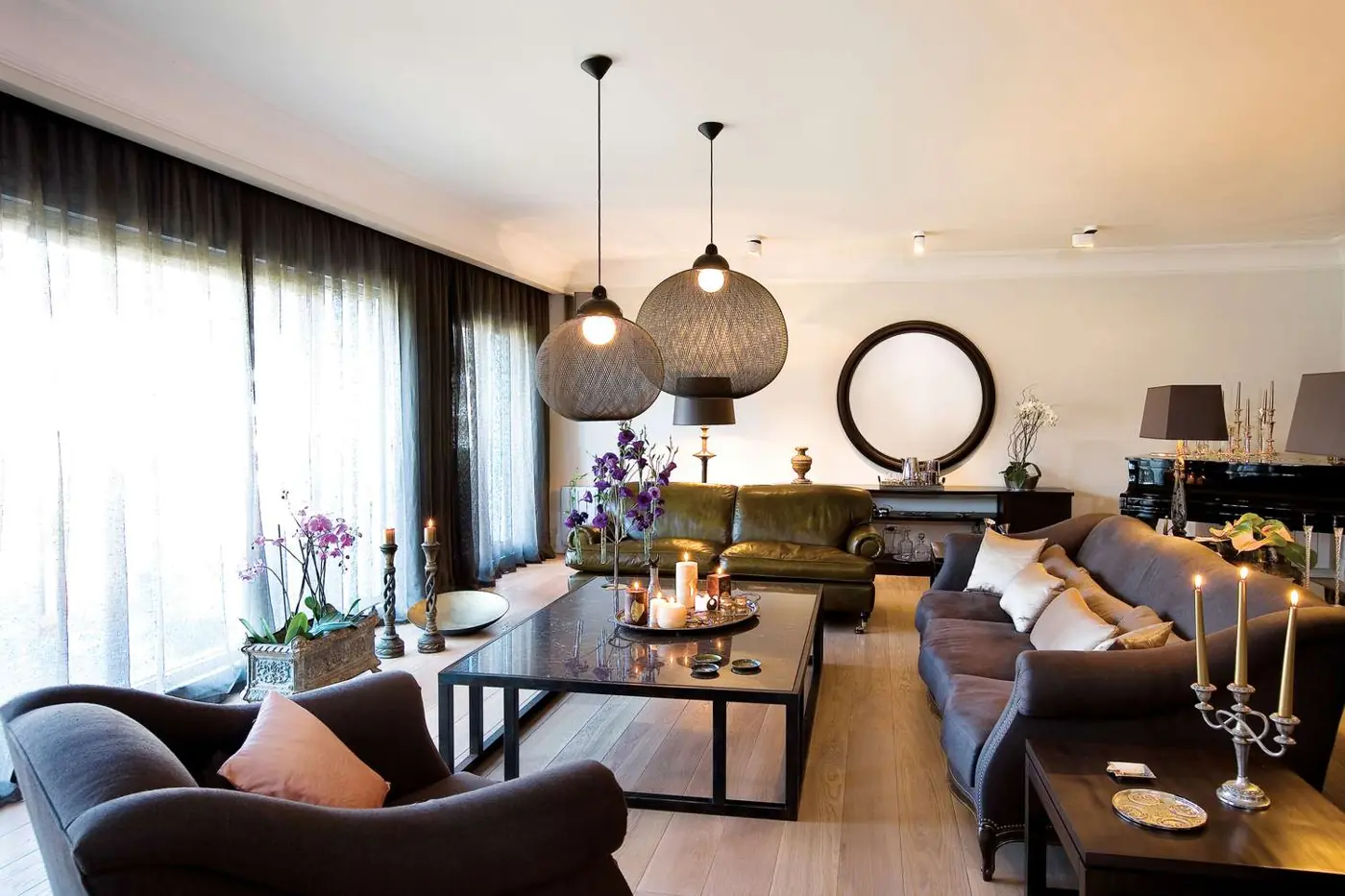 Pendant lights, table lamps and candles spread across a living room.